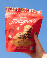 Hand holding a bag of Fancypants S'mores cookies against a blue sky.