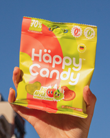 Hand holding a package of Happy Candy's Big Apple flavor blend of gummies.