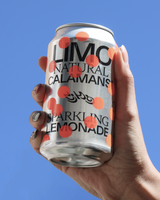 Hand holding a can of LIMO Natural Calamansi Sparkling Lemonade against a blue sky.