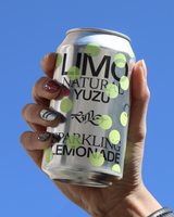Hand holding a can of Limo's Natural Yuzu Sparkling Lemonade against a blue sky.