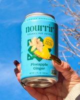 Hand holding NOURRIR - Pineapple Ginger Sparkling Juice