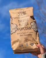 Hand holding Popzup Popcorn - Truffle Butter Popcorn