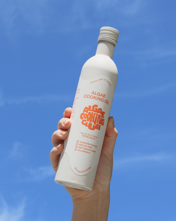 Hand in air holding Algae Cooking Club - Algae Cooking Oil