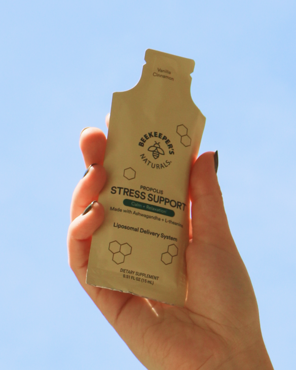 Hand holding a pouch of Beekeeper's Naturals Propolis Stress Support. 