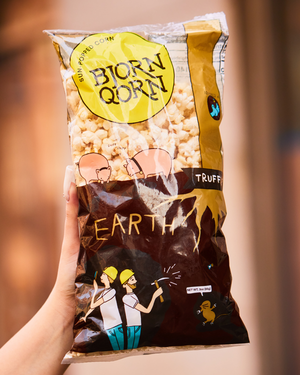Large bag of Bjorn Qorn's Truffle popcorn against a blurred background. 