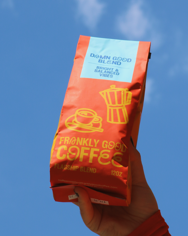 Hand holding a bag of Frankly Good Coffee's Damn Good Blend. 