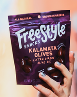 Hand holding a bag of Freestyle's Kalamata Olives.