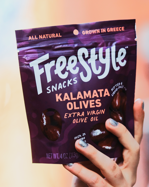 Hand holding a bag of Freestyle's Kalamata Olives.
