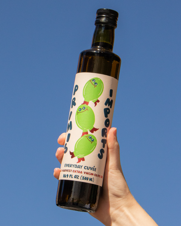 Hand holding Primis Imports - Everyday Cuvée Extra Virgin Olive Oil